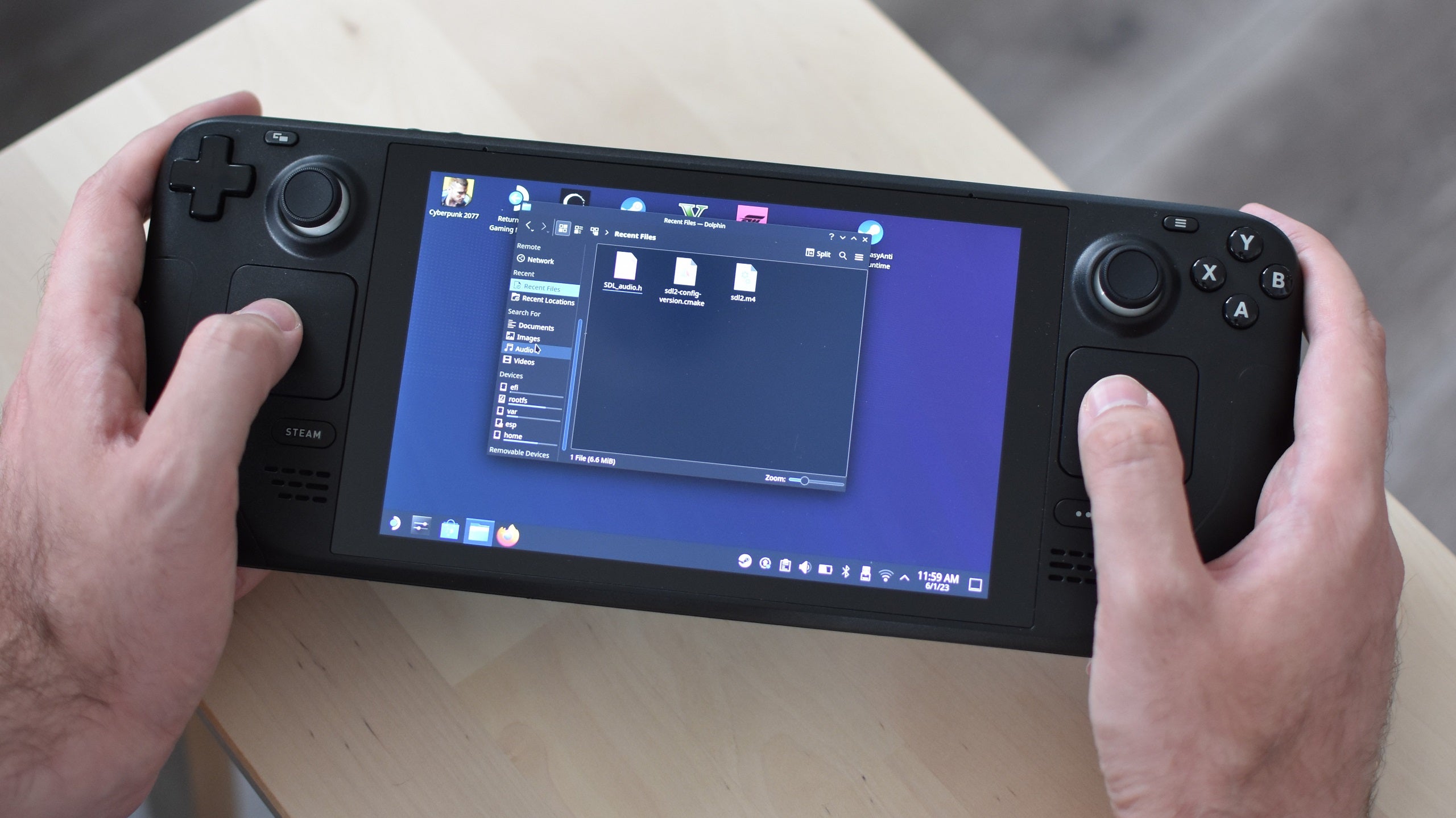 A Steam Deck in desktop mode, with the right trackpad being used to move the cursor.