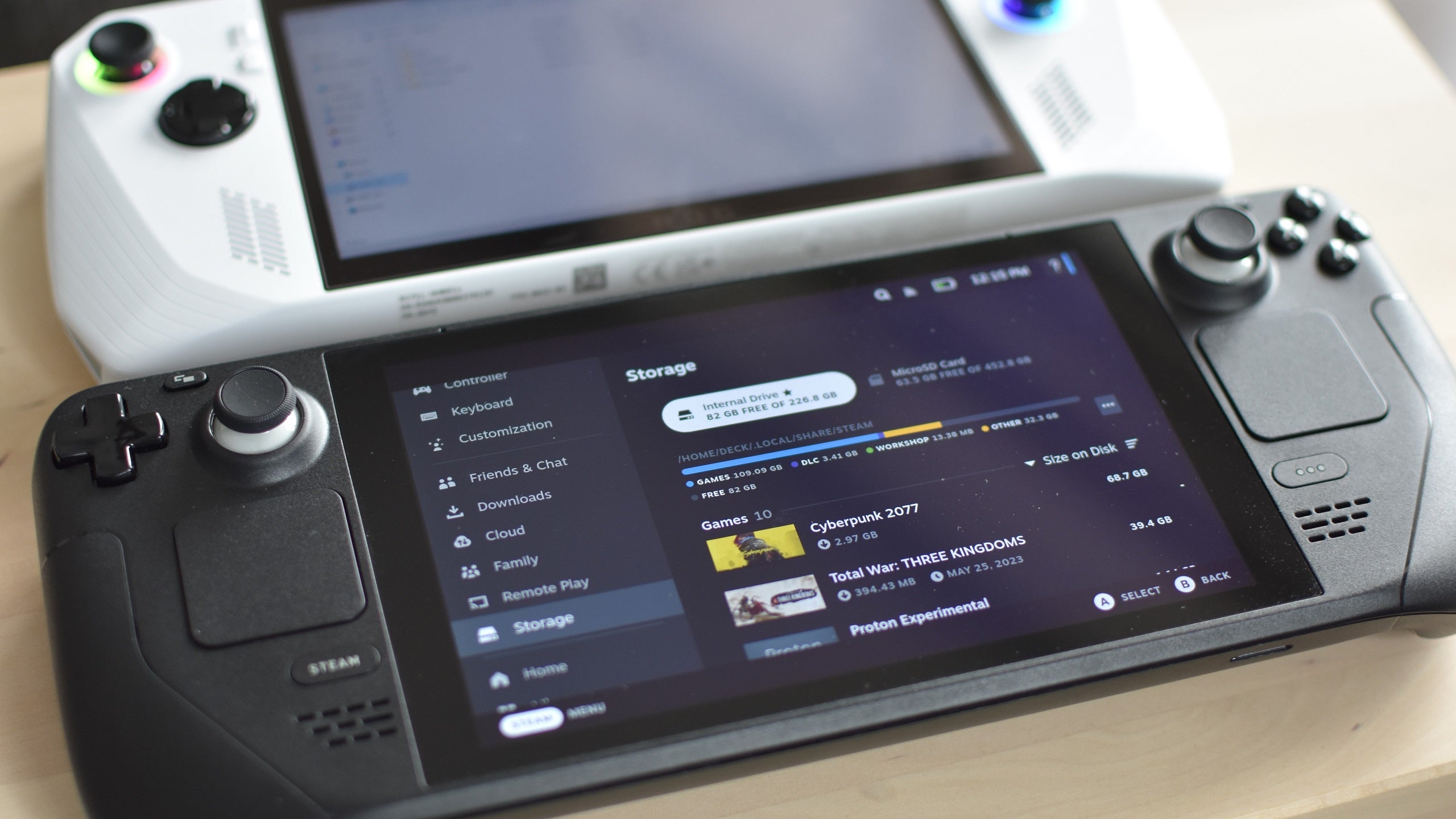 A Steam Deck, next to an Asus ROG Ally, showing its storage management menu.