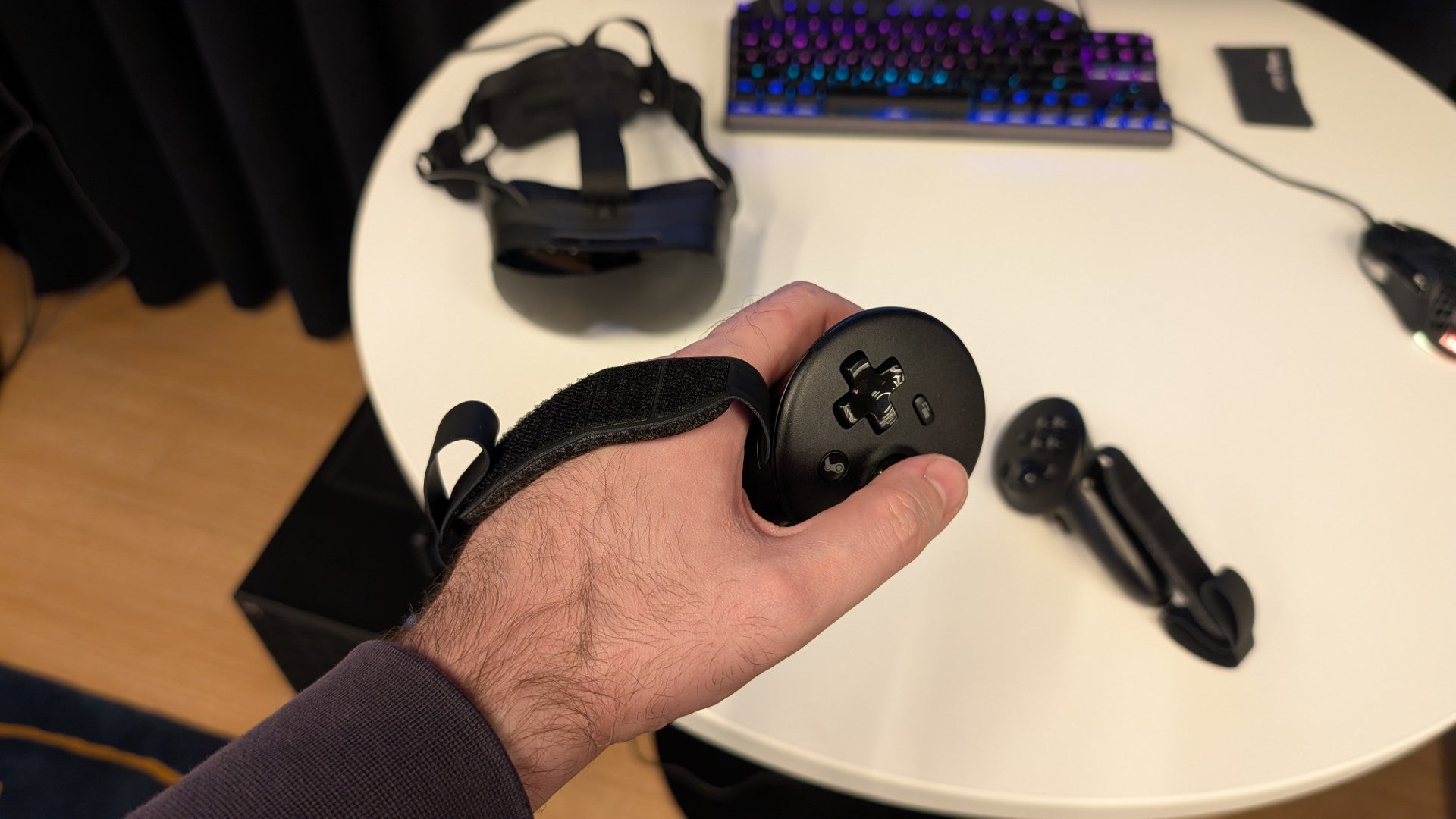 The left controller for the Steam Frame VR headset, affixed to a user's hand with a strap. - 4