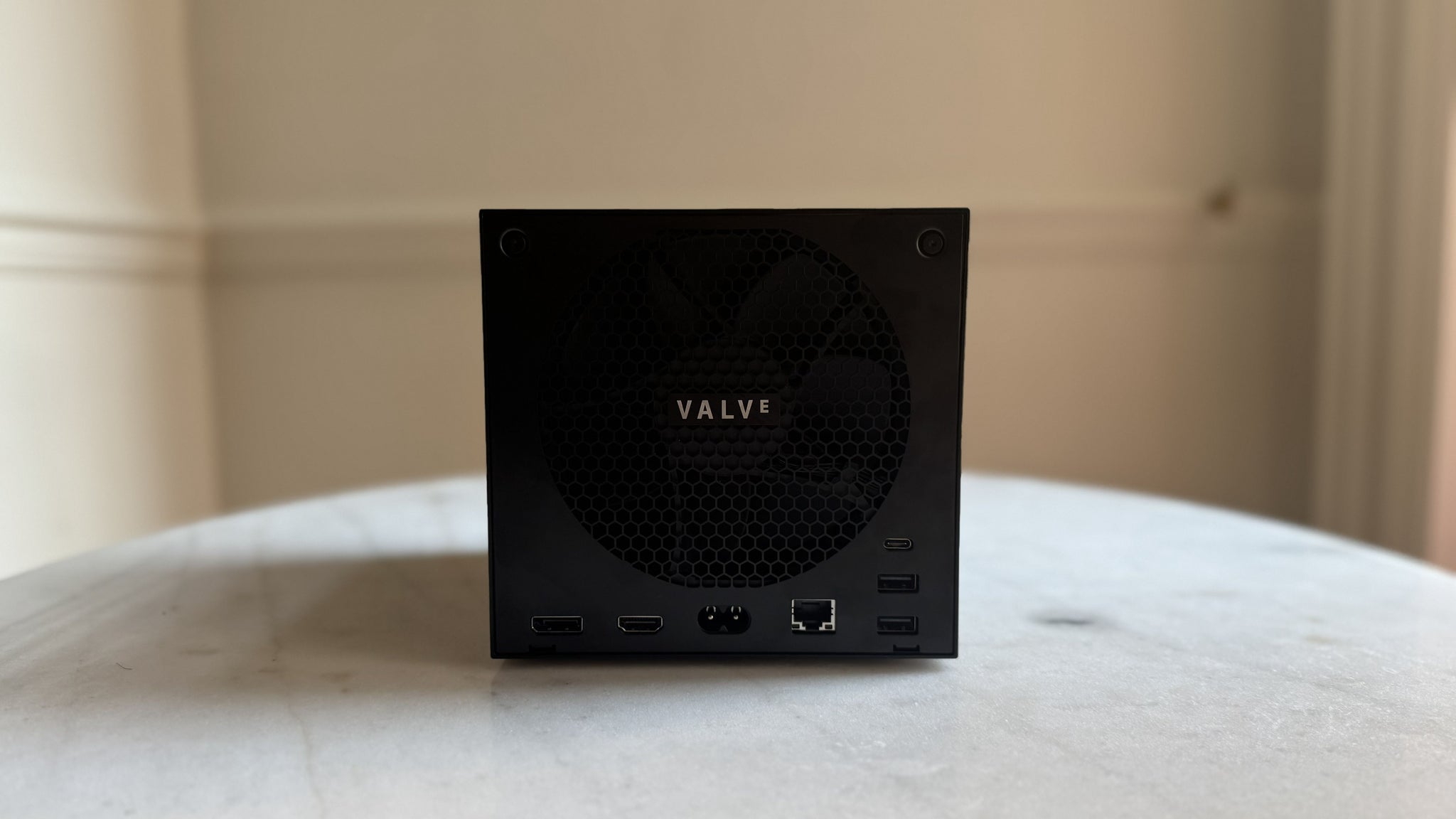 Steam Machine photograph showing the steam machine from behind on a marble circular table in front of a grey/beige wall