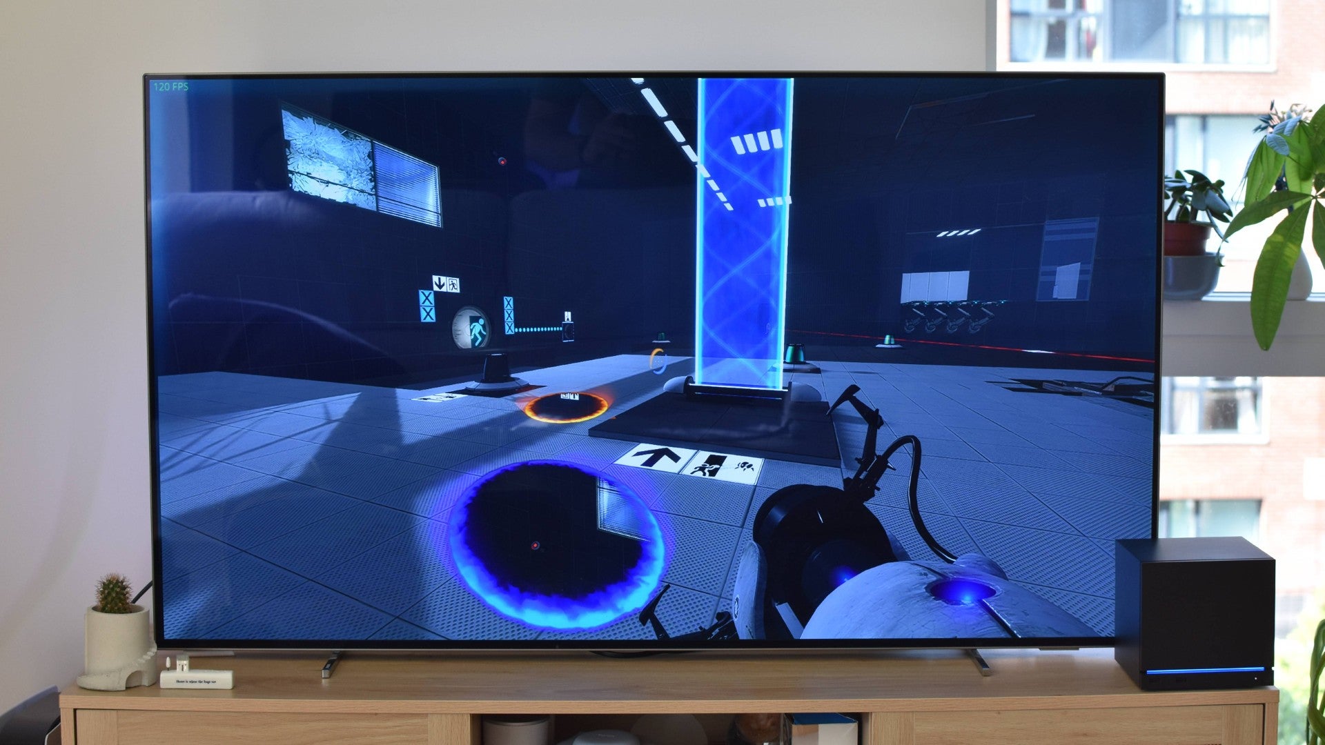A TV, connected to a Steam Machine, running Portal 2.
