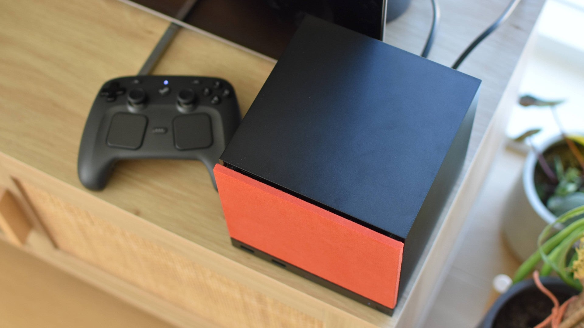 A top-down view of a Steam Machine next to a Steam Controller.