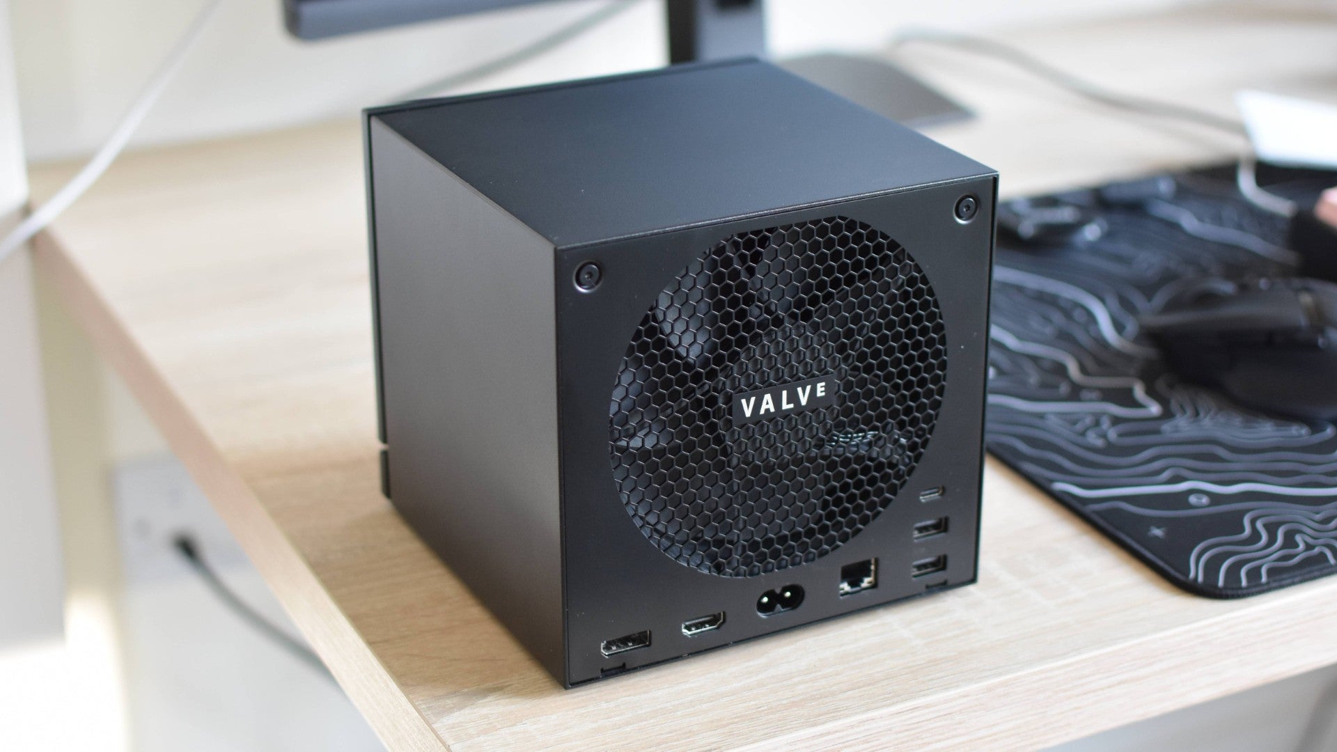 The rear panel of a Steam Machine, showing its fan grate and rear ports.