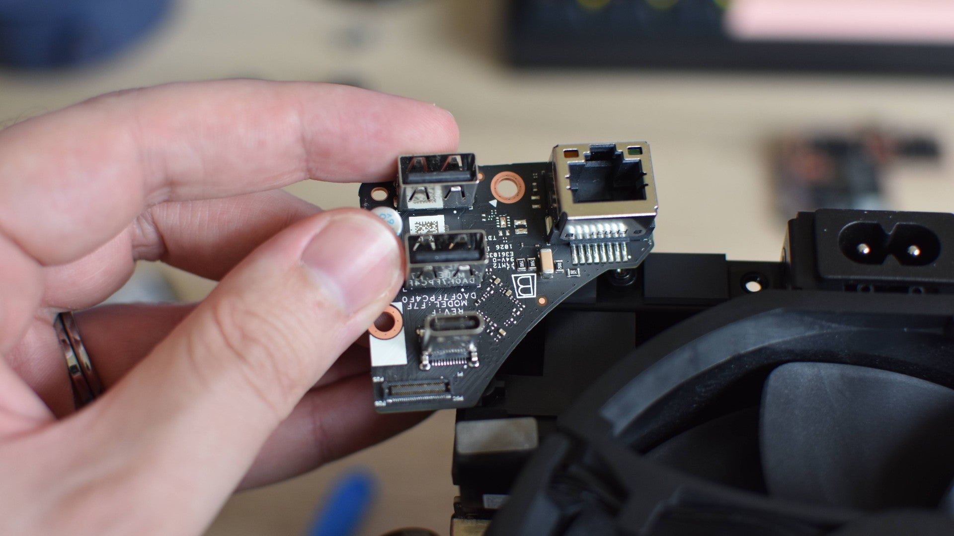 Removing the rear I/O daughterboard from a Steam Machine's internal assembly.