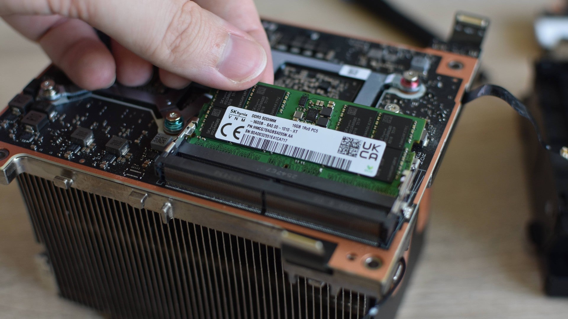 Removing the preinstalled DDR5 RAM module from a Steam Machine's internal assembly.