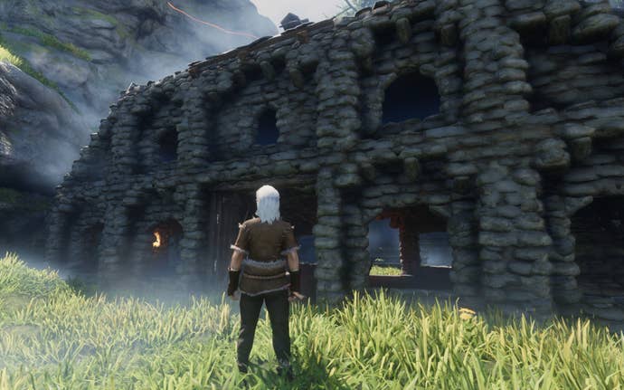 Enshrouded screenshot showing A woman stands in front of a stone building, which has elaborate arches over its window frames, made possible by Enshrouded’s building system.