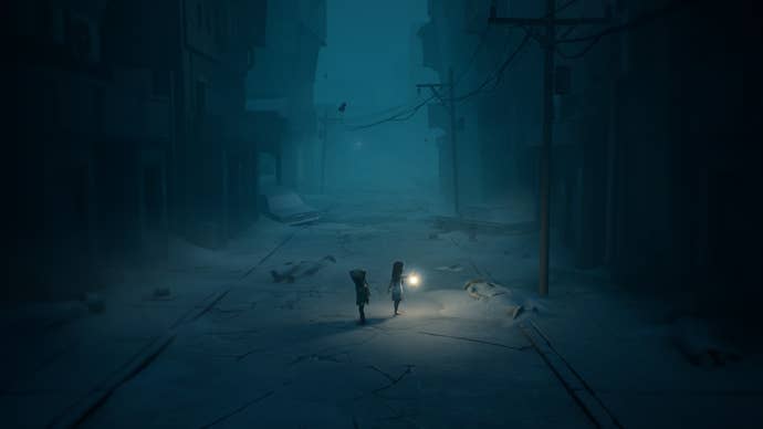 A Reanimal screenshot showing two children as they wander along a narrow, fog-shrouded street with a lantern held high.