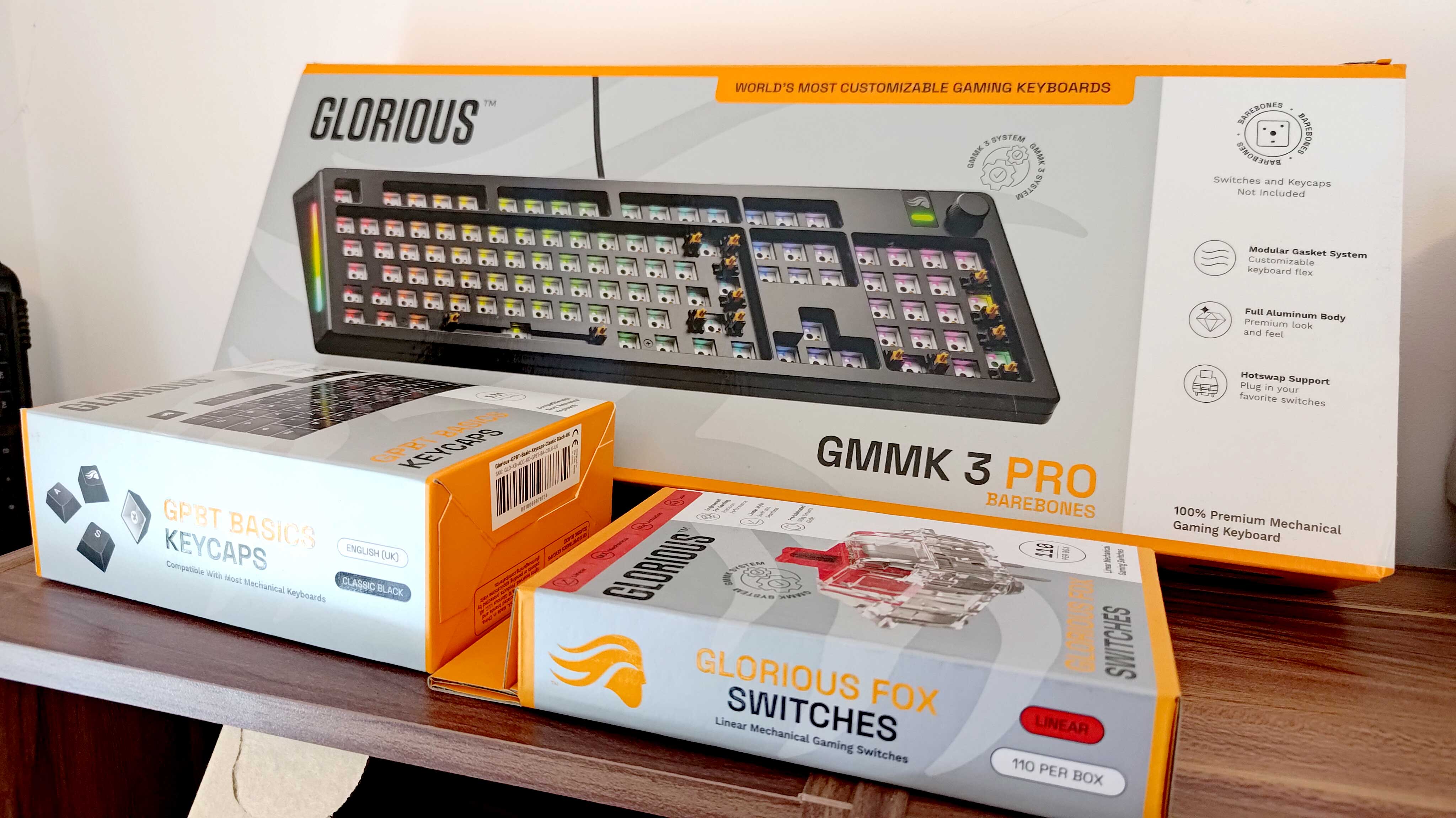 The packaging for a Glorious GMMK 3 Pro keyboard, alongside two boxes of custom key switches.