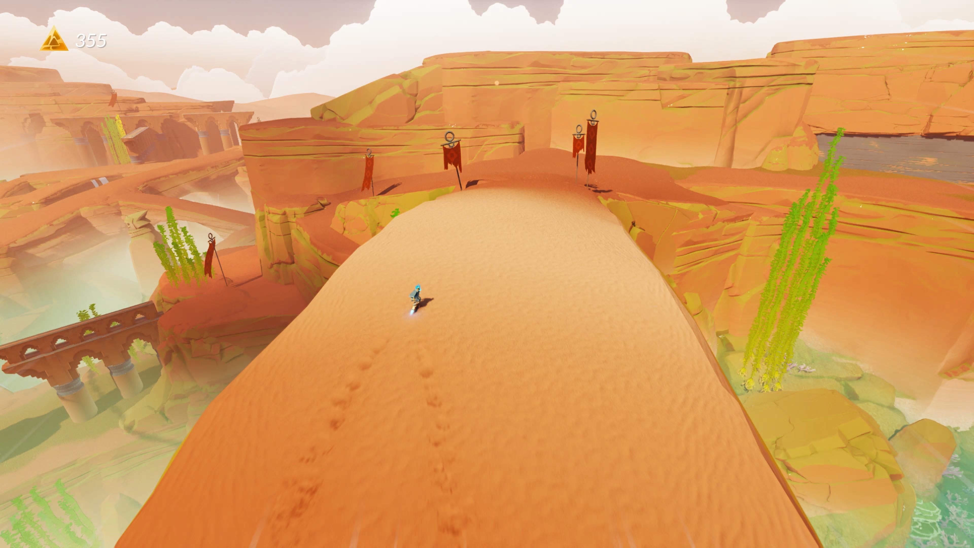 Sword of the Sea screenshot showing a zoomed-out show of your tiny surfer on a sandy bridge