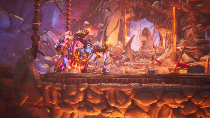 Captura de pantalla de Tales of Kenzera que muestra al personaje principal contra un enorme jefe enmascarado en una caverna ardiente
