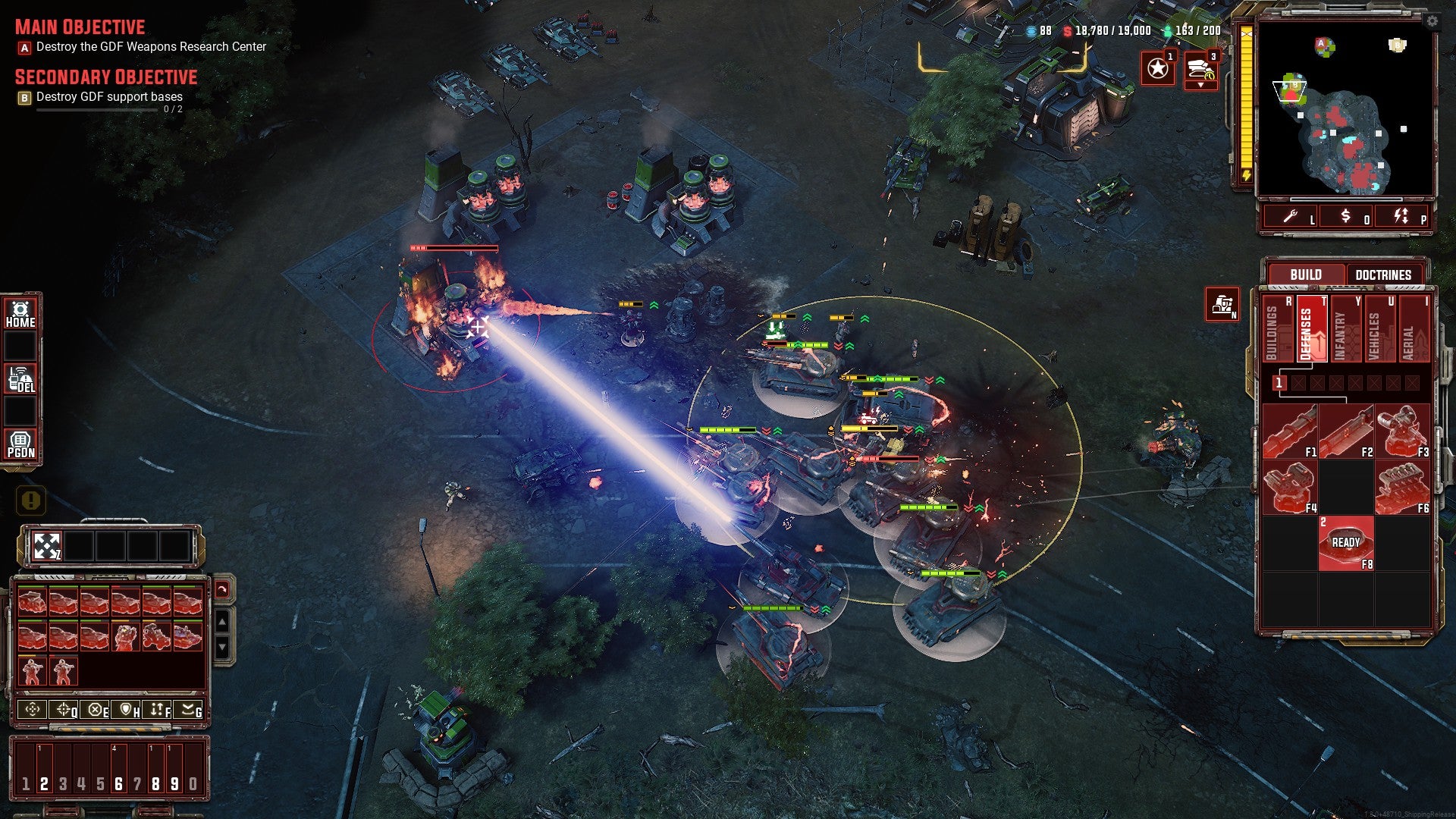A group of tanks, one of them firing a laser cannon, work on destroying a base in Tempest Rising.