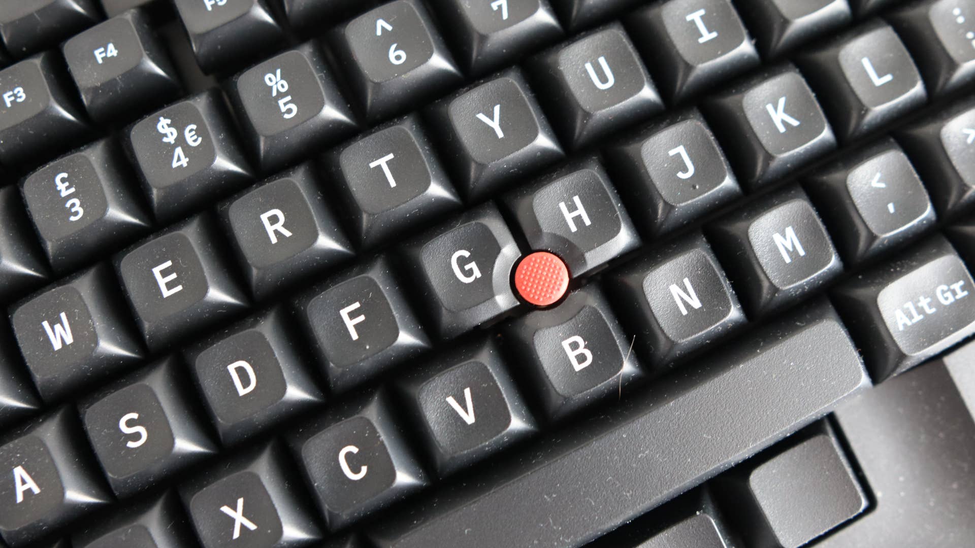 Close -up do trackpoint no teclado tex shinobi no fundo cinza