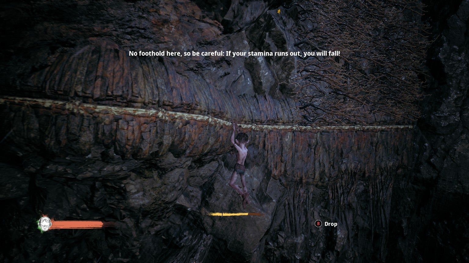 Gollum hangs from a ledge on the side of a mountain in The Lord Of The Rings: Gollum