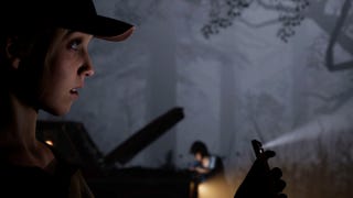 Laura uses her phone as a torch in the forest of The Quarry, Max can be seen behind her at their car.