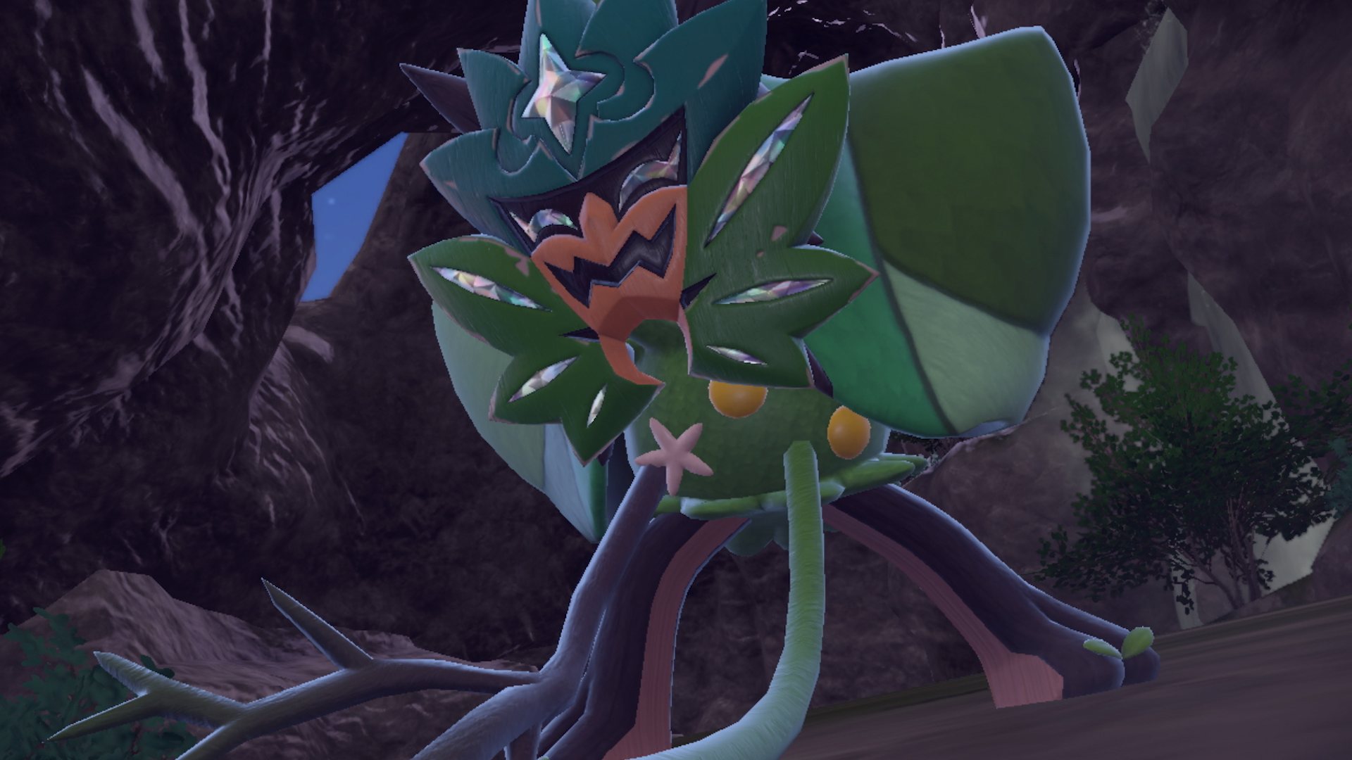 Pokémon The Teal Mask screenshot showing the DLC&rsquo;s legendary Pokémon with a green mask on in a cave