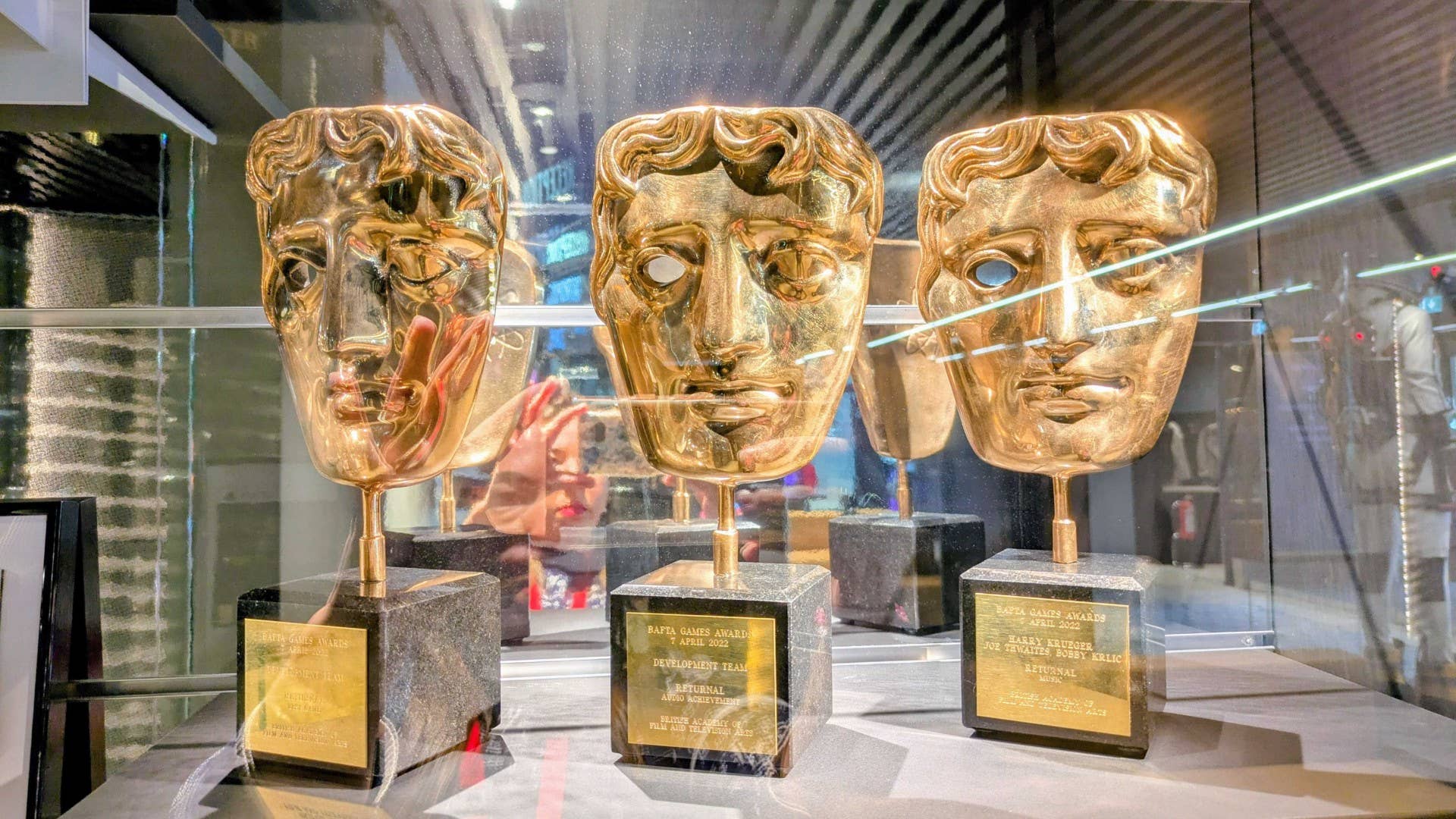 Three of Housemarque's BAFTA awards in a glass case