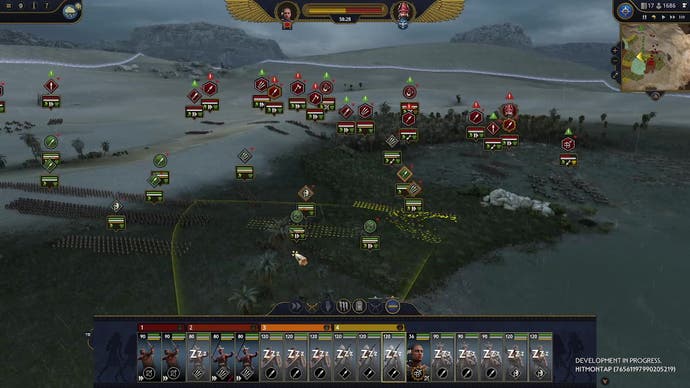 Total War Pharaoh preview - screenshot showing a dimly lit battle with sand to the left and a watery oasis to the right, with enemy chariots slowed by mud