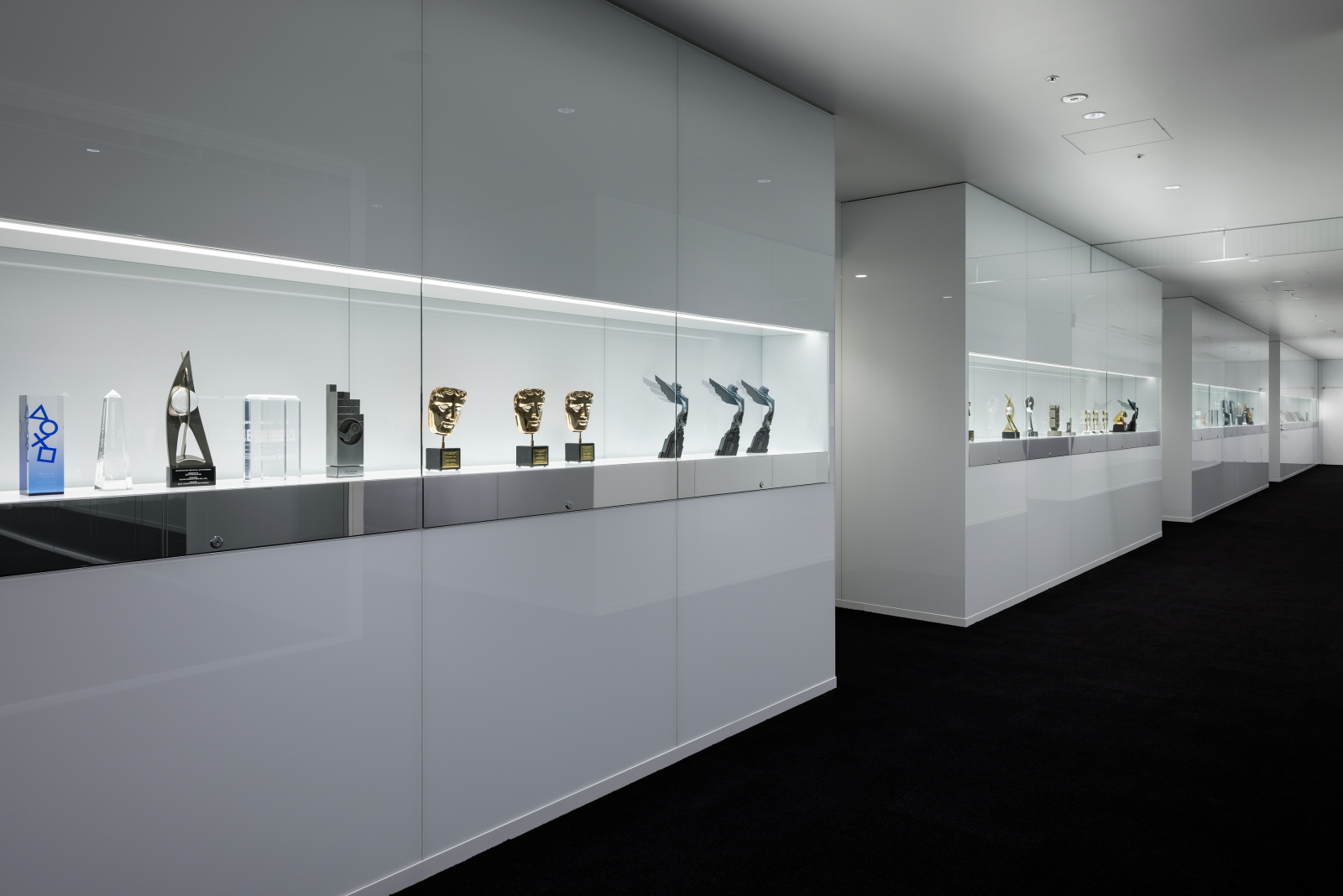 A corridor filled with trophies in a glass cabinets in Kojima Productions