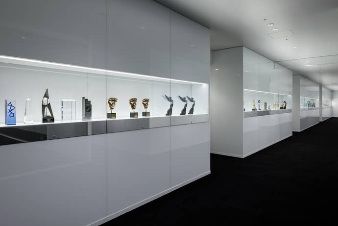 A corridor filled with trophies in a glass cabinets in Kojima Productions