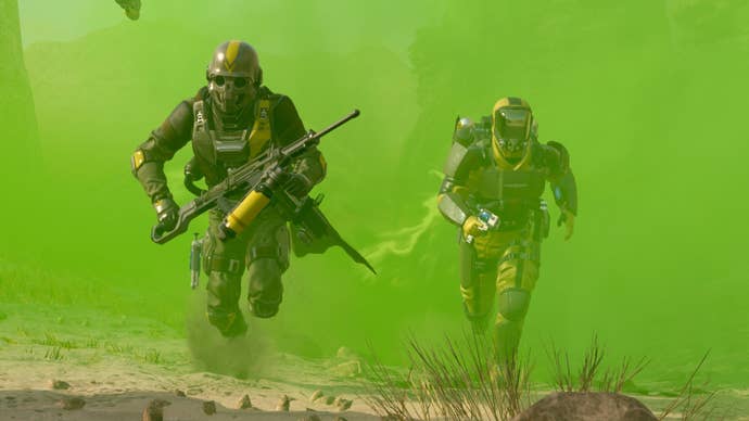 Two Helldivers run through a green mist in Helldivers 2