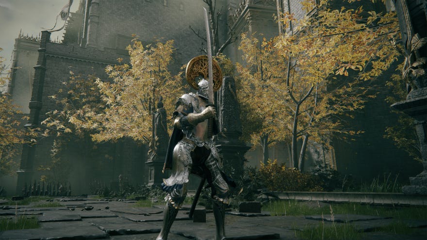The player in Elden Ring stands holding an Uchigatana in the outskirts of a castle.