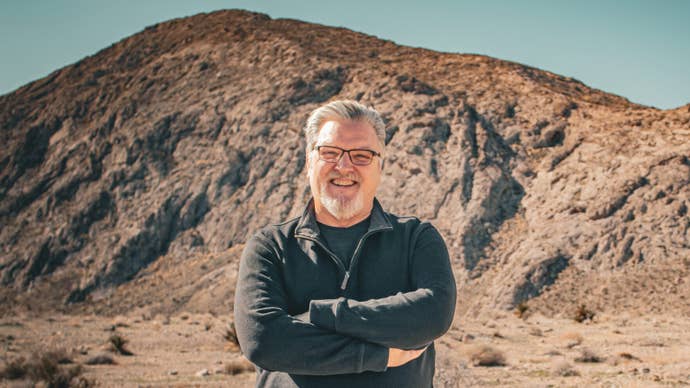 Photograph of former Bungie composer Marty O’Donnell standing in front of a rocky outcrop in an area that looks vaguely Martian.
