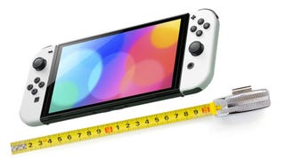 A Switch OLED console lays next to a tape measure.