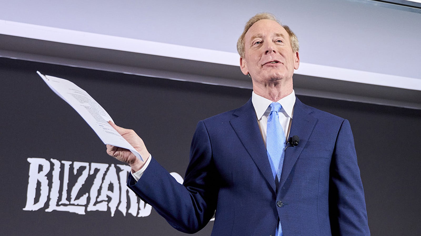Microsoft&rsquo;s Brad Smith holds up his unsigned PlayStation contract.