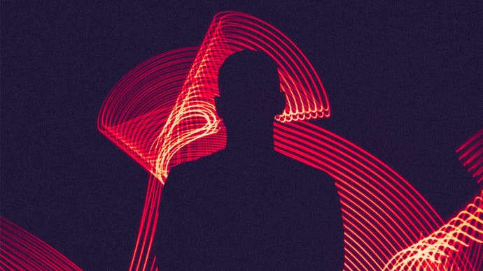 A silhouette of a person in front of neon lights.