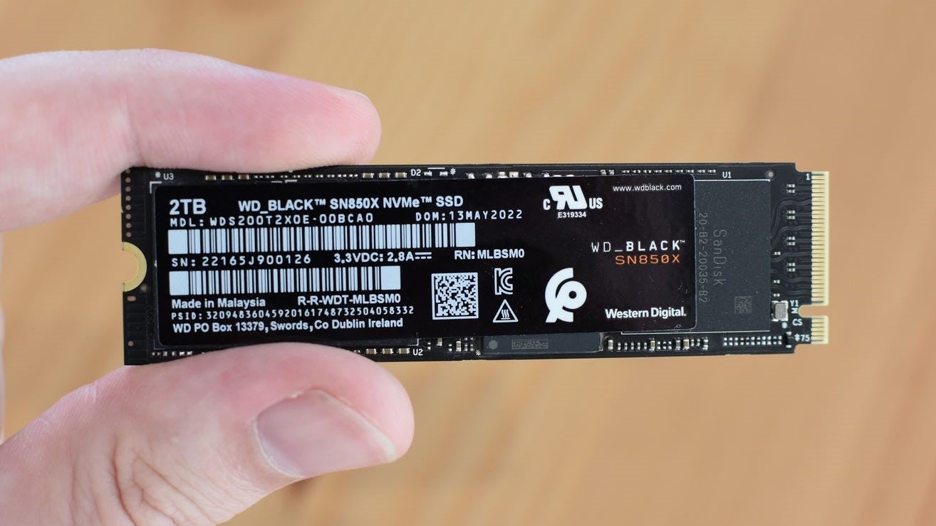 The WD Black SN850X SSD, being held between a finger and thumb. - 4