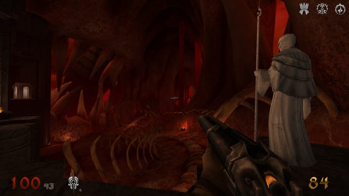 A screenshot of Wrath: Aeon of Ruin, depicting the player inside a large hub area made of flesh and bone, standing beside a white, bald figure holding a staff.