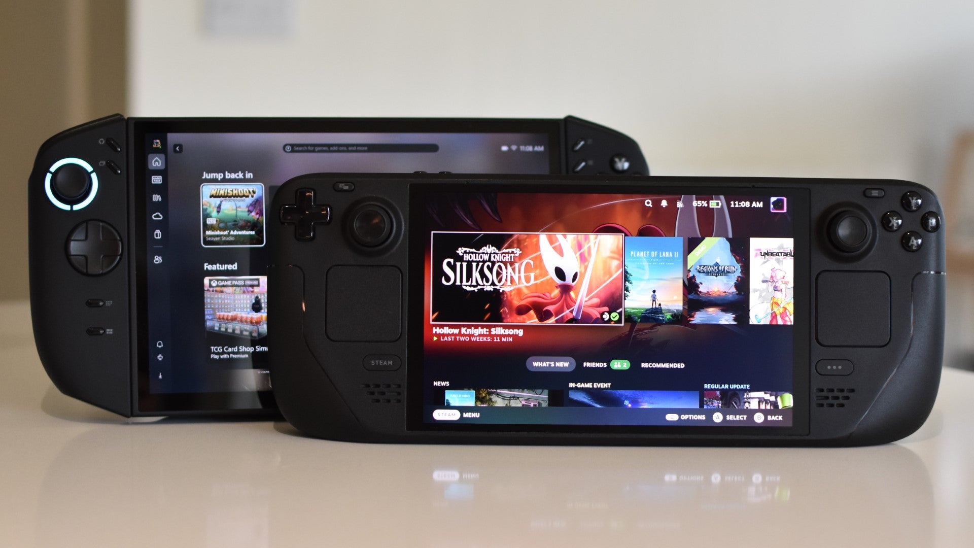 A Steam Deck OLED (running SteamOS) in front of a Lenovo Legion Go 2 (running Xbox Full Screen Experience).