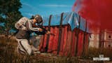 A player squats behind a red crate on PUBG's Erangel Classic map.