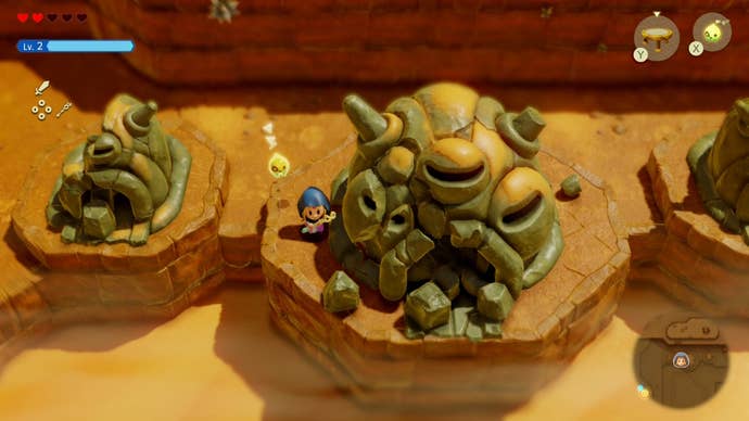 Zelda standing beside a crumbling statue in Zelda Echoes of Wisdom.