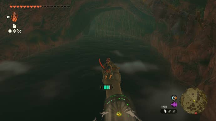 Link rides a raft made from a log and fan through the Sarjon Cave in The Legend of Zelda: Tears of the Kingdom