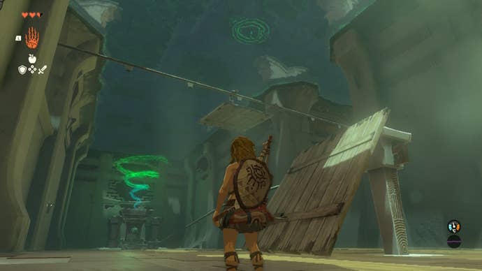 Link looks up at a platform riding along a rail in the Ukouh Shrine of The Legend of Zelda: Tears of the Kingdom