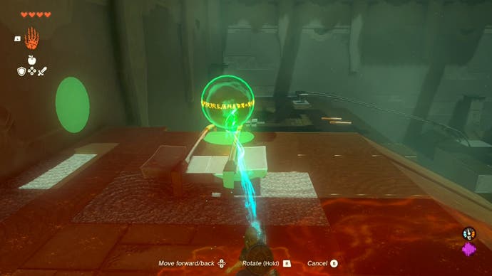 Link using the Ultrahand ability to move a large metal ball in the Runakit Shrine.