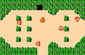 Link faces off against several enemies in a sandy stretch of land surrounded by green mountains. There&rsquo;s a cave entrance at the top of the screen.