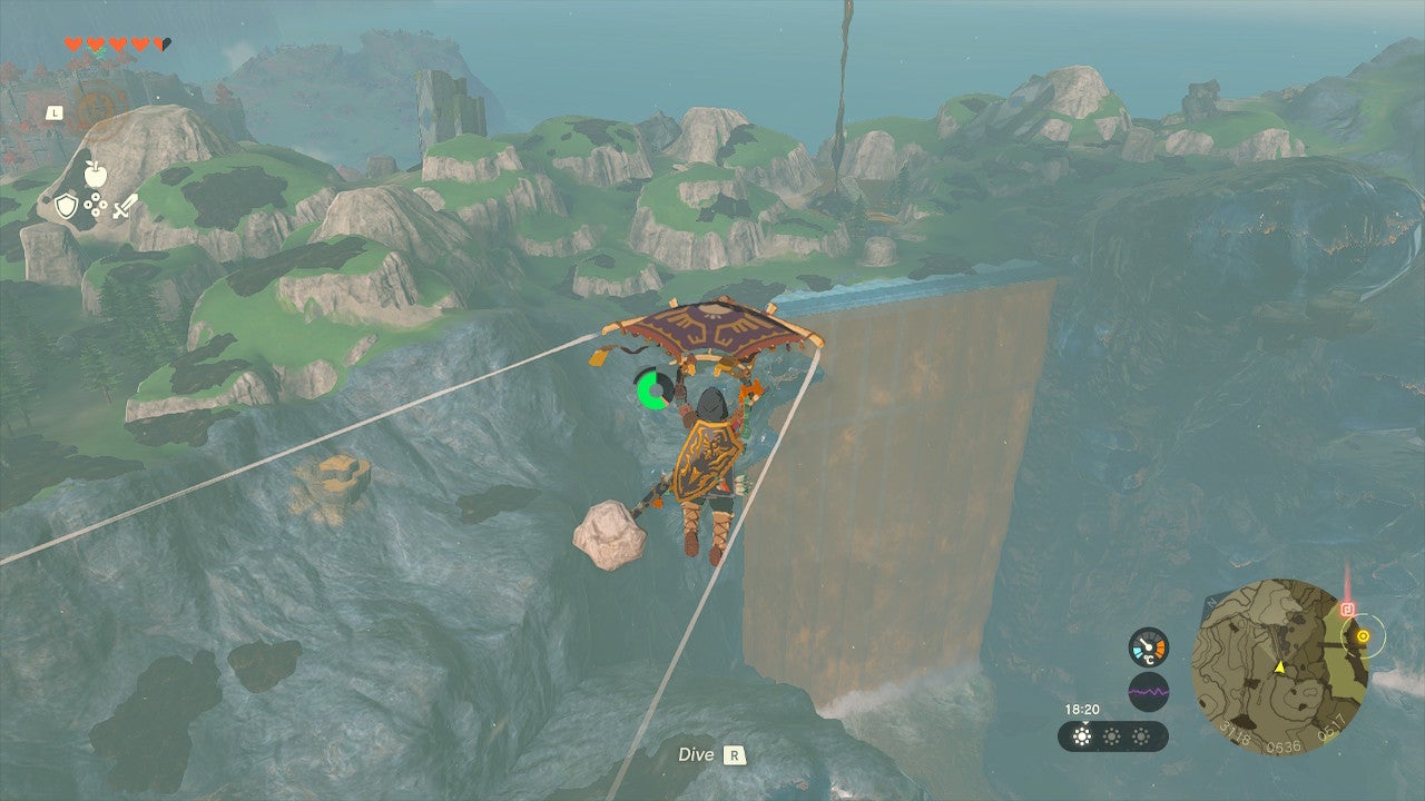 Link gliding through the air and approaching a giant, wide waterfall in Hyrule.