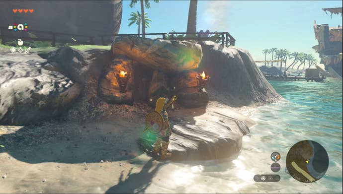 Link standing by the Lurelin Village Goddess Statue in the Rabella Wetlands region in Zelda: Tears of the Kingdom.