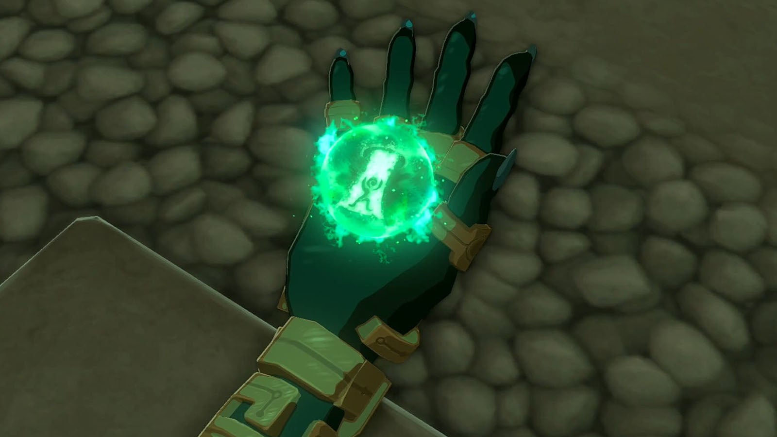 Image taken from The Legend of Zelda: Tears of the Kingdom showing a close-up of Link&rsquo;s hand with a glowing green orb, as the character learns the Ascend ability.