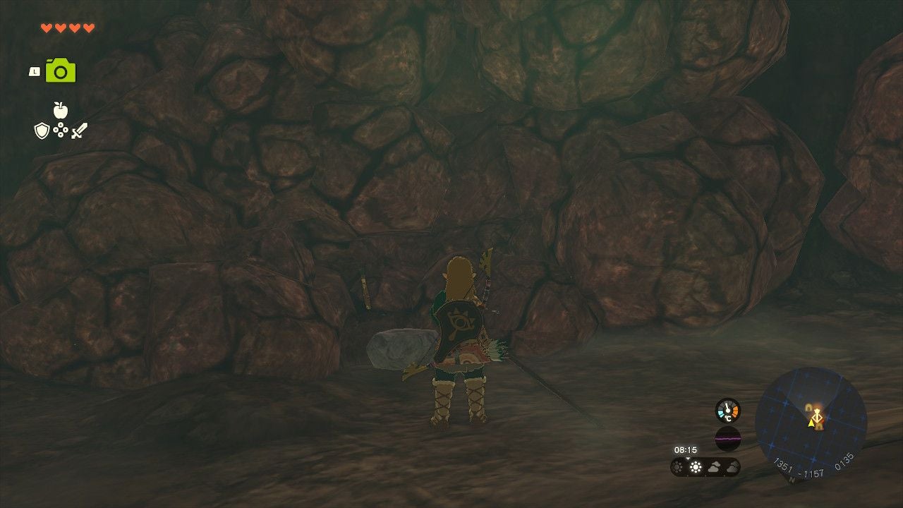 Link standing next to breakable rocks lining the walls of the Sahasra Slope Cave.