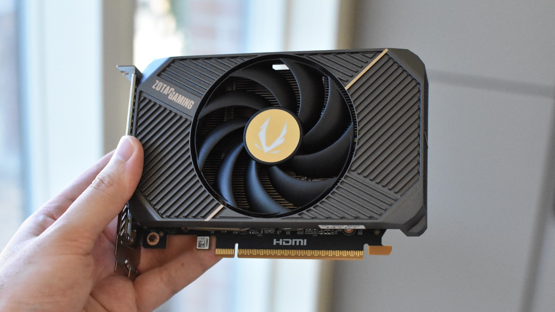 The Zotac Gaming GeForce RTX 5060 Solo graphics card, held in a hand. - 1