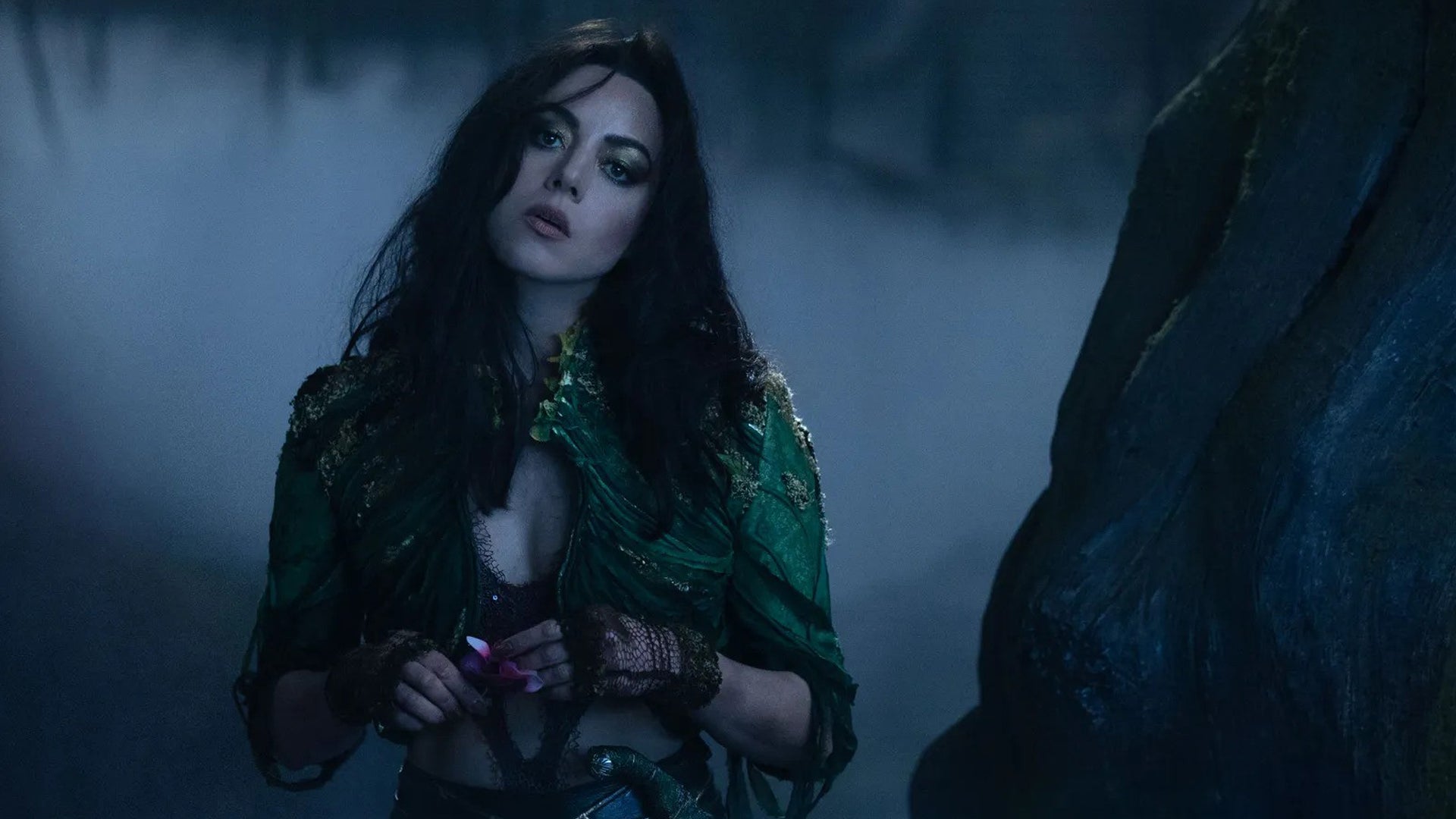 Aubrey Plaza as Rio Vidal in Agatha All Along, she looks curious about something, her head tilted, and she&rsquo;s stood in some foggy woods.