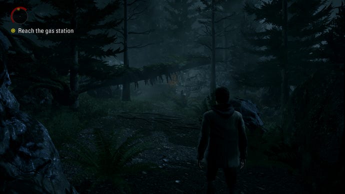 A screenshot of Alan Wake Remastered, showing Alan on a forest path.