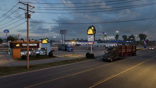 A work-in-progress screenshot from American Truck Simulator's Arkansas expansion showing a truck pulling into a Taco Kingdom diner at dusk