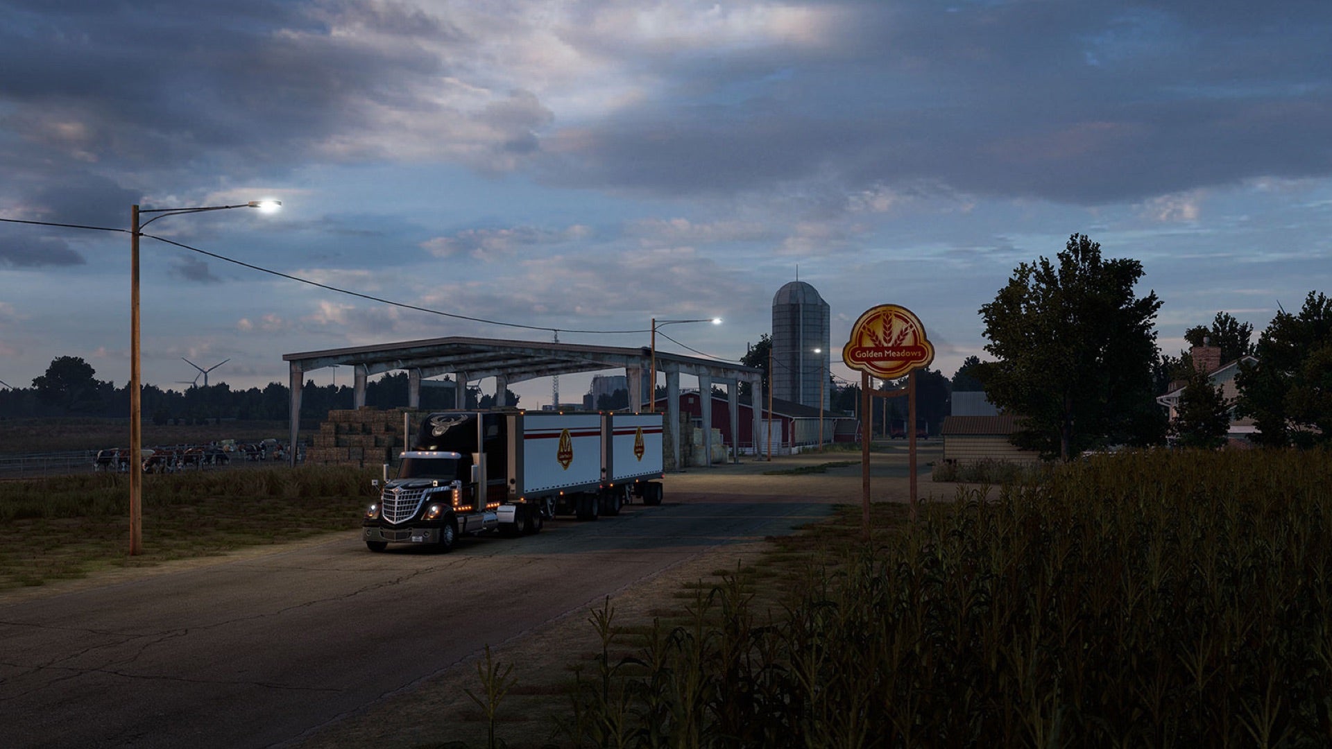 A screenshot of American Truck Simulator&rsquo;s Kansas expansion, showing a truck driving away from the Golden Meadows farm at dusk.