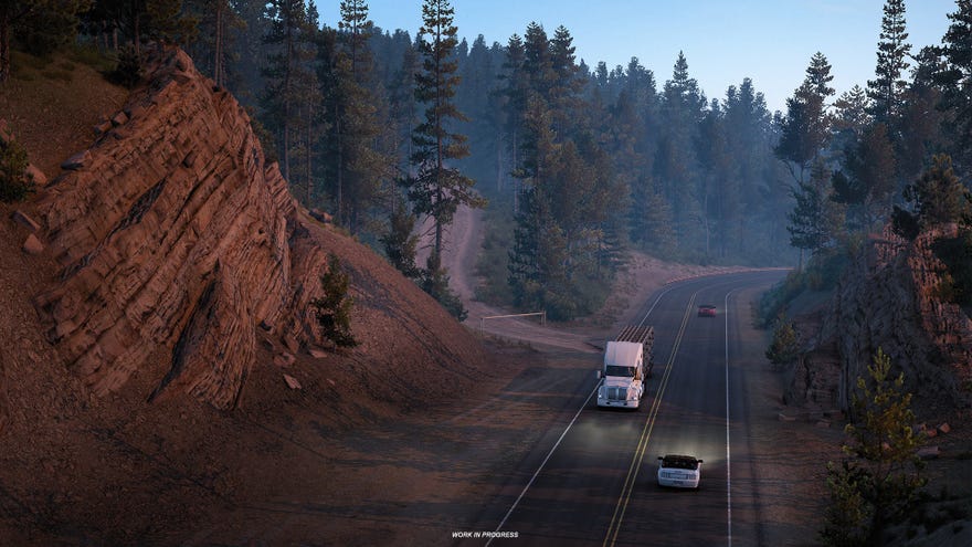 Lots of trees behind a road with a truck on it driving towards the camera in American Truck Simulator’s Montana DLC.