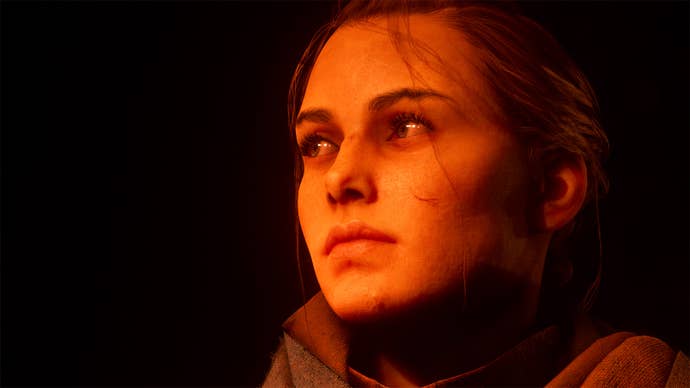 Amicia from A Plague Tale: Requiem. It’s a close-up image and her face is bathed in orange light. We can see the cuts on her face. She gazes off to the left of the image with a yearning look in her eye.