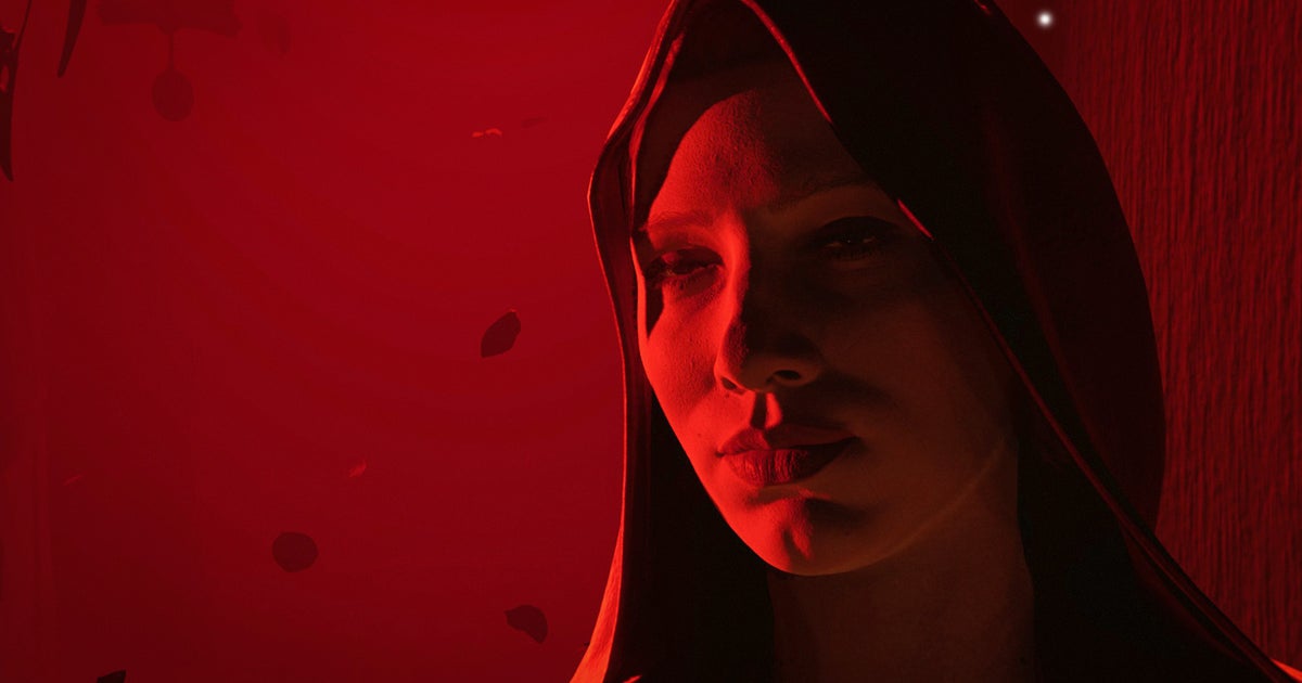 Photo: eurogamer.net A hooded woman in a strong red light, looking forlorn